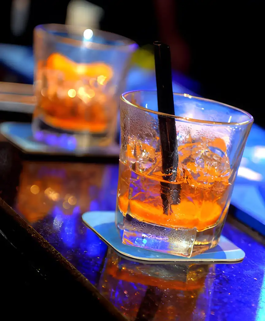 Craft cocktails with orange garnish on lounge table — beverage photography Dubai