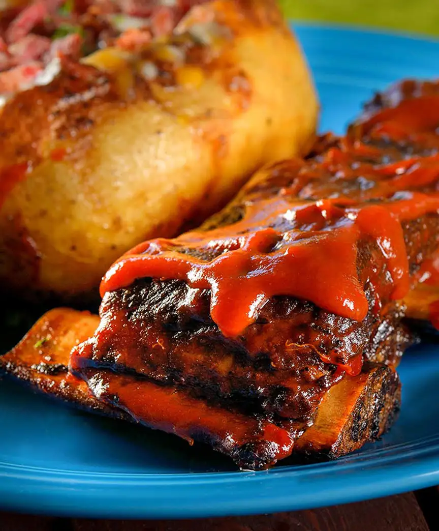 BBQ ribs with sauce and baked potato — commercial food photography Dubai