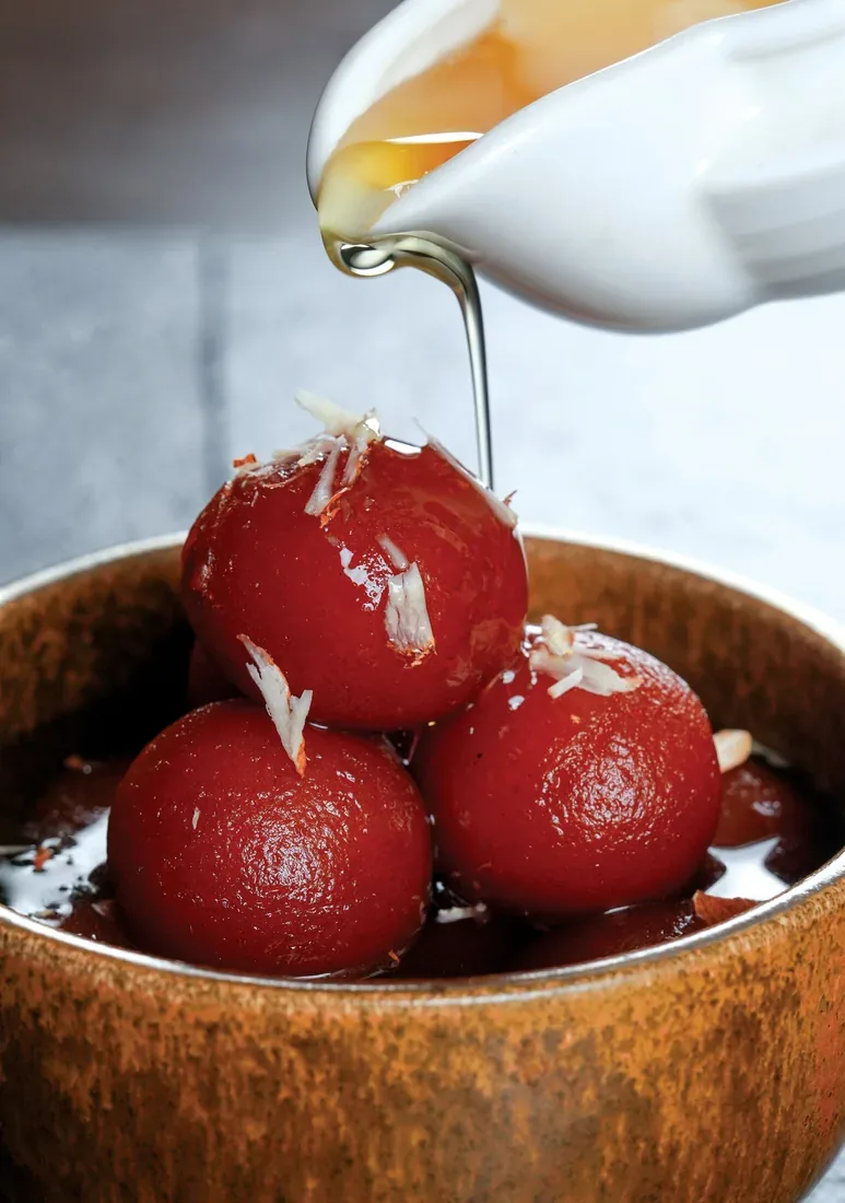 Gulab jamun with sugar syrup being poured — food photography Dubai
