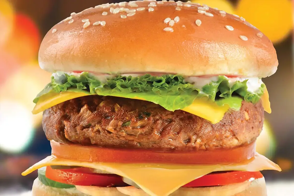 Loaded beef burger with melted cheese shot against a warm bokeh backdrop, food photography for a Riyadh restaurant